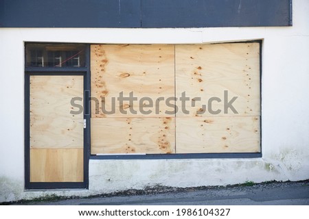 Shop front with blank sign and closed shutter door