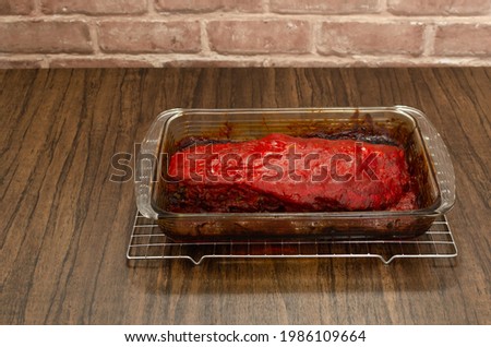 Roasted ribs marinated with barbecue sauce on wooden table.