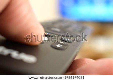 man watching television In the mobile remote and select press netflix to see the list of movies.