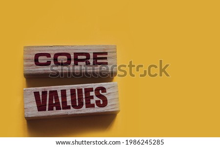core values words on wooden blocks on yellow background. Business ethics concept.