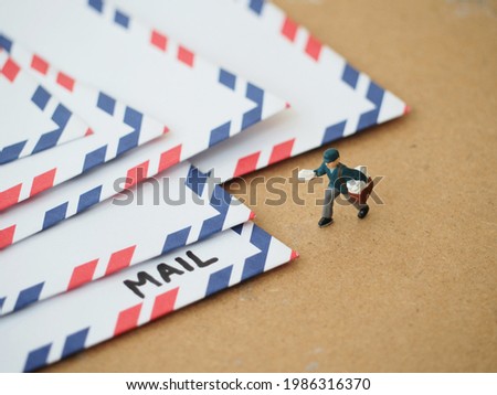 Miniature figure toys with paper mail letters on the brown table.