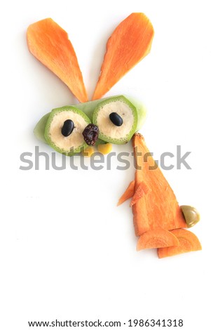 Food art creative concepts. Funny bunny rabbit made of fruits and vegetables, such as carrots and cucumber isolated on a white background.