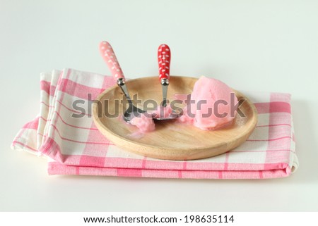 pink ice cream in wooden plate on white background