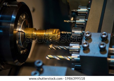 The multi-tasking CNC lathe machine swiss type making the thread on brass shaft parts. The hi-technology metal working processing by CNC turning machine .