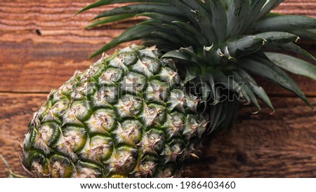 Pineapples on a brown wooden table in Thailand.