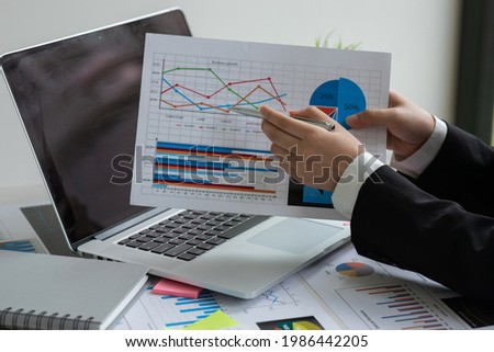 Businesswoman hands hold documents with financial statistic stock photo,discussion and analysis data the charts and graphs.Finance, Market research reports and income statistics and Accounting concept