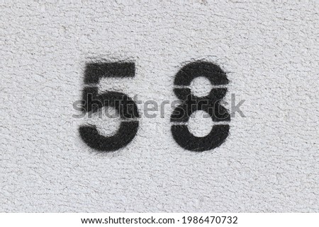 Black Number 58 on the white wall . Spray paint.
