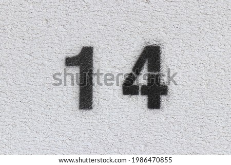 Black Number 14 on the white wall . Spray paint.
