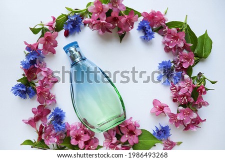 flower composition. frame of pink flowers and a set of perfume bottles on a white background