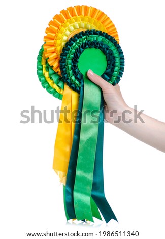Yellow green award ribbons in hand on white background isolation