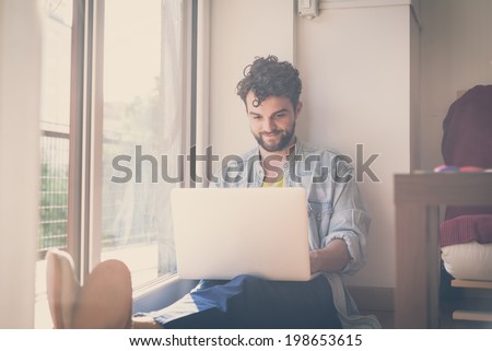 handsome hipster modern man designer working home using laptop at home Royalty-Free Stock Photo #198653615