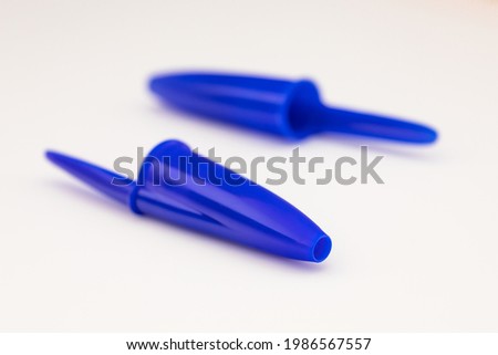 Plastic pen lids on white background Royalty-Free Stock Photo #1986567557