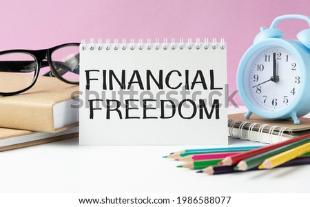 Business concept - Top view notebook writing Financial Freedom