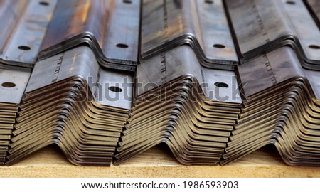 A stack of sheet metal products after processing on a bending machine. Royalty-Free Stock Photo #1986593903