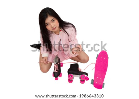Top view photo of young woman in pink dress sitting on the ground tying skate shoelaces on white background.