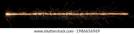 Sparkler trail of light with sparks in a straight line. Royalty-Free Stock Photo #1986656969