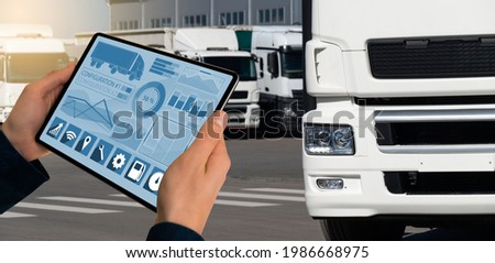 Manager with a digital tablet on the background of trucks. Fleet management Royalty-Free Stock Photo #1986668975