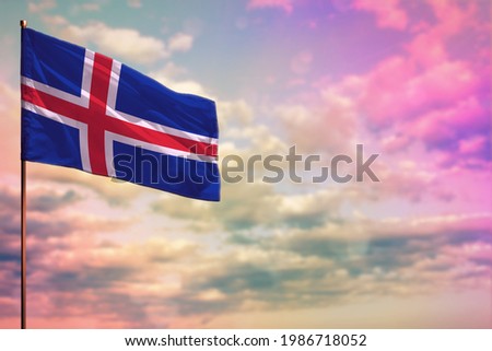 Fluttering Iceland flag mockup with the place for your text on colorful cloudy sky background.