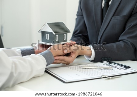 The real estate agent gives the house to a new owner's client after completing the signing of the lease and formally completing home insurance. Rental and insurance concepts.