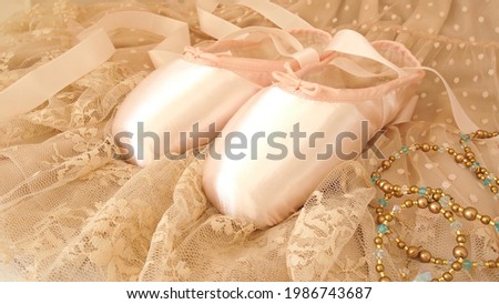 A tiara made of beads and pointe shoes placed on a tutu made of beige lace. Close-up. space. Diagonally above.