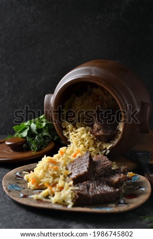 Pilaf bowl (plov, pilaw, pilau) top view. Traditional middle east cuisine. Uzbekistan dish made of rice, beef , spices, carrot, onion and garlic.