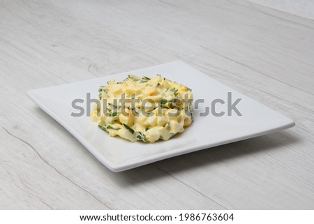 portion of boiled egg salad with herbs and white sauce. selective focus 