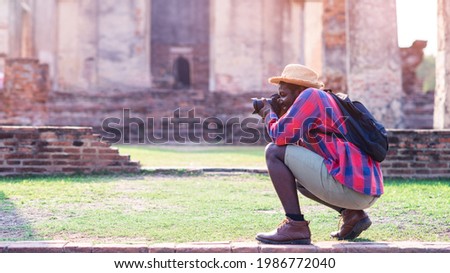 African male photographer enjoying to taking pictures of ancient scenery with beautiful asia old buildings