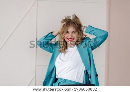 Young business woman in blue suit posing in a photo studio
