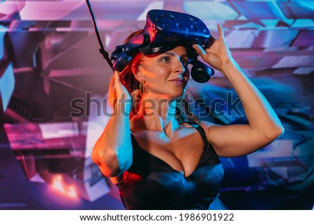 Virtual reality. Woman puts on a virtual reality helmet.