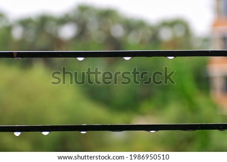 A picture of raindrops on a window grill on a rainy day during monsoon in Mumbai, Maharashtra, India.