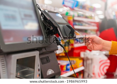 close up human female hand 
 with pos cashier machine Retail, credit card payment service. Customer paying for order of cheese in grocery supermarket store shop. Royalty-Free Stock Photo #1986965993