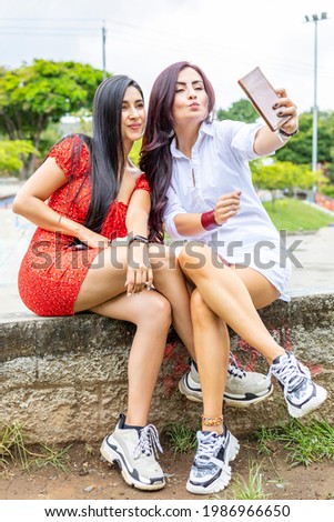 Two young women taking a selfie outdoors