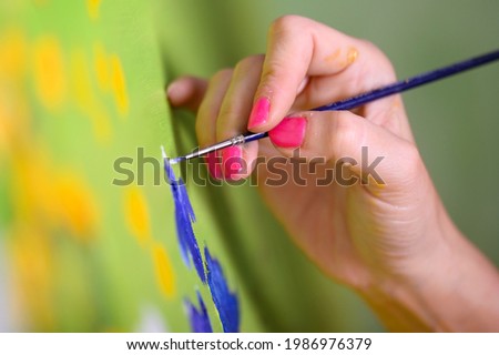 Close-up Shot of Female Artist Hand, Holding Paint Brush and Drawing Oil Painting. Contemporary Painter Creating Modern Abstract Piece of Fine Art. High quality photo