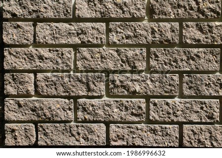 A fragment of a brown brick wall. The texture of the stone. Close-up