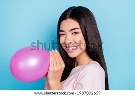 Profile side photo of young asian girl happy positive smile blow air balloon decoration isolated over blue color background