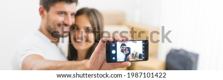 The happy couple make a photo on the background of the carton boxes
