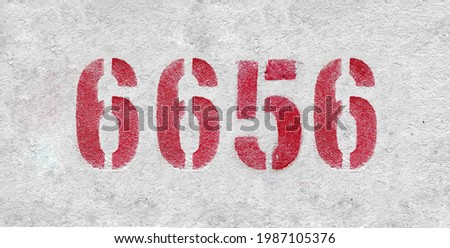 Red Number 6656 on the white wall. Spray paint.