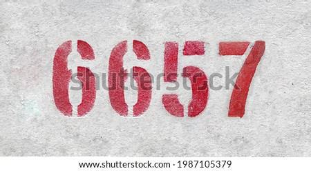 Red Number 6657 on the white wall. Spray paint.