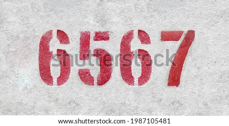 Red Number 6567 on the white wall. Spray paint.