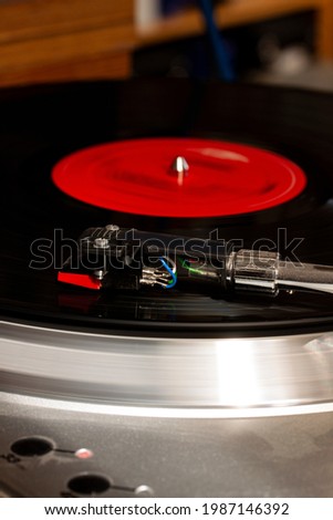 Record usb player turntable with its stylus running on record. Retro styled spinning record vinyl player.
