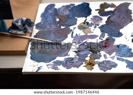 A palette with multi-colored paint and brushes for drawing. High quality photo