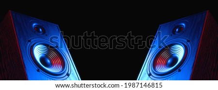 Two sound speakers in neon light with free space between them on black. Royalty-Free Stock Photo #1987146815