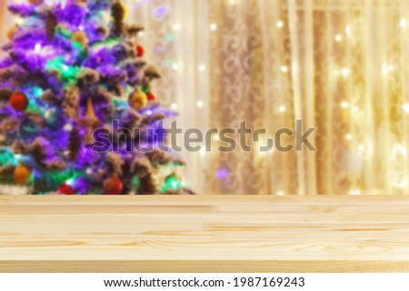 wood table top on blur christmas tree with garland background