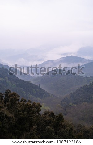 Cloudy and foggy mountain landscape from the top of a hill