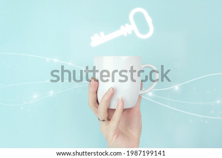 Succes key. Cropped view of female hand with white coffee cup and sign Key Keyword Icon on blue background