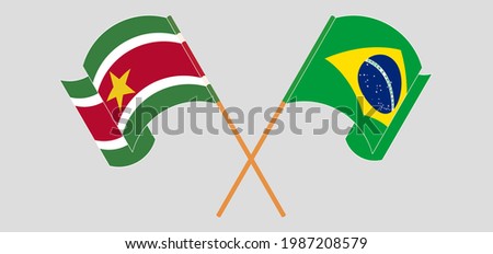 Crossed and waving flags of Suriname and Brazil