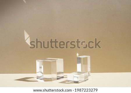 Minimal modern product glass display on textured background in neutral earth tones with shadows