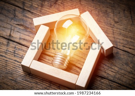 house shape made by wooden block with light bulb inside. energy saving concept. estate business conceptual. . Royalty-Free Stock Photo #1987234166