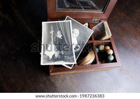 closeup old wooden box, a stack of retro photos, a lock of hair, vintage photographs of 1960, concept of family tree, genealogy, childhood memories