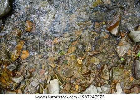 Water abstract from high angle the water makes reflections over the rocks Royalty-Free Stock Photo #1987247573
